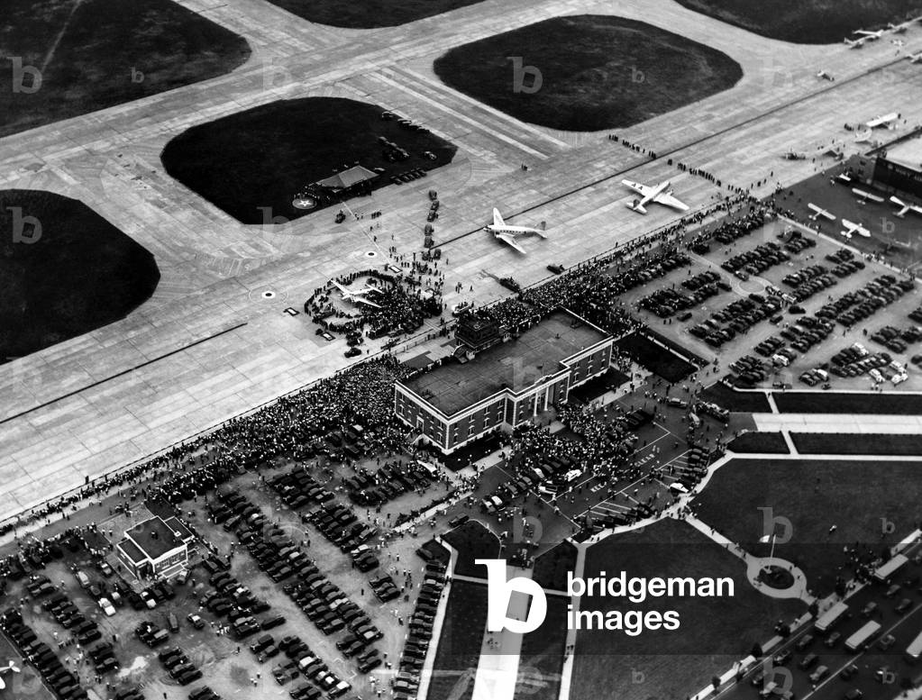 Howard Hughes lands at Floyd Bennett Airport in his silver monoplane after completing his record-breaking 91 hour flight around the world. New York, July 14, 1938