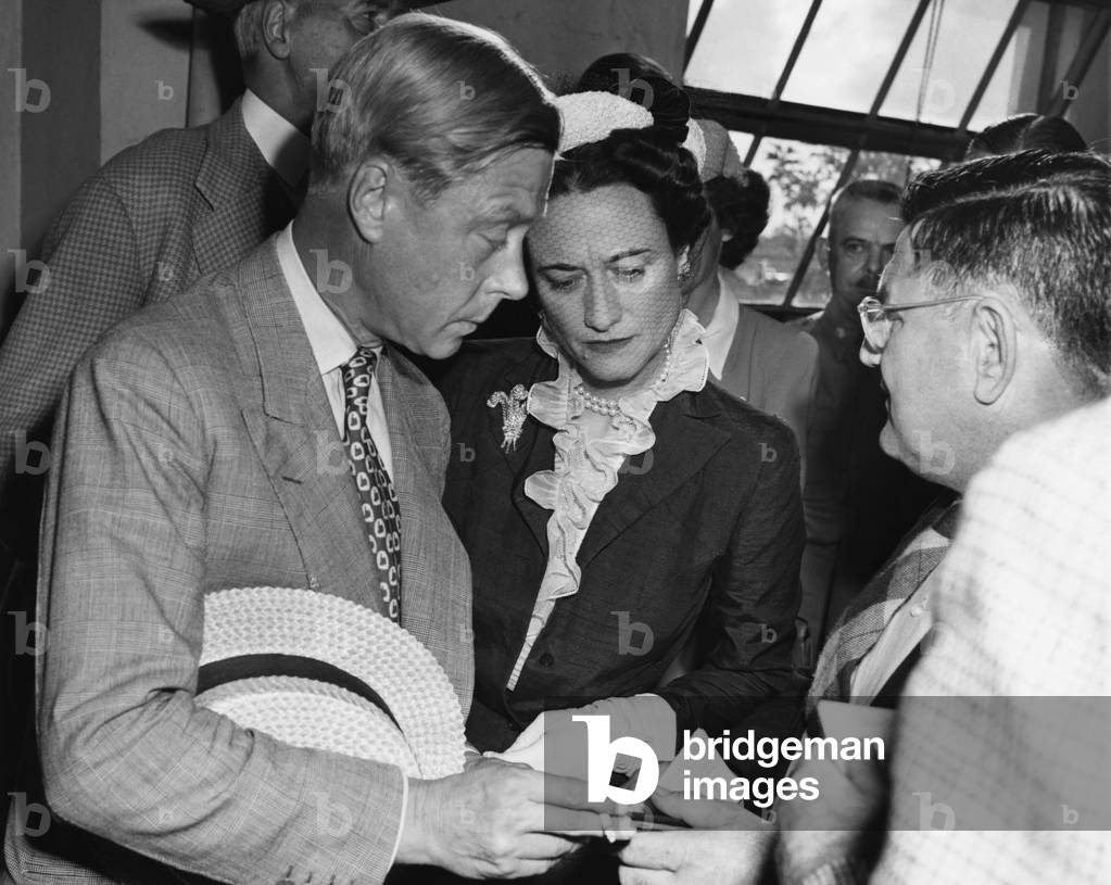 From left: Prince Edward, Duke of Windsor and Duchess of Windsor Wallis Simpson receive their passports from Miami police captain E.W. Melohen upon arriving in Miami, Florida, 1942