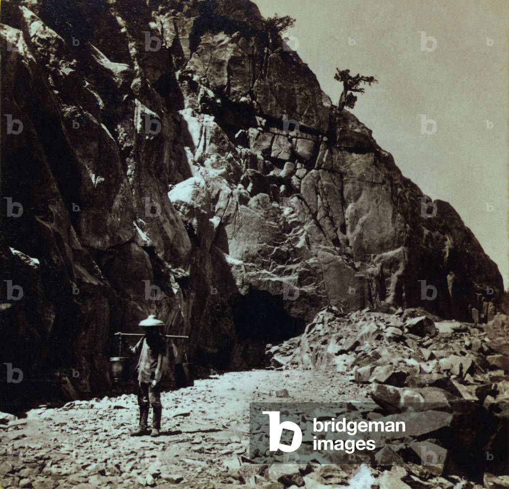 Chinese railroad worker wearing traditional clothing and hats while working on the Central Pacific Railroad, in the Sierra Nevada Mountains of California. The Central Pacific Railroad recruited large labor groups to build its portion of the Transcontinental railroad. c. 1867