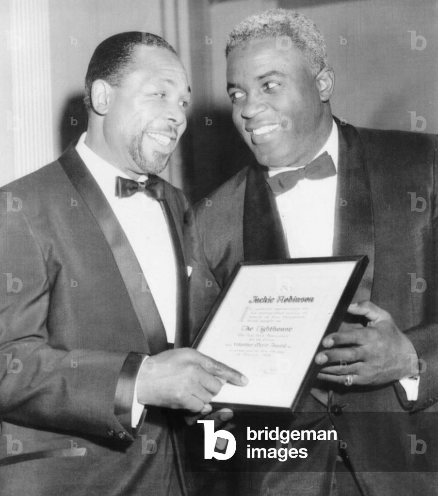 Light heavyweight champion Archie Moore talks with ex-baseball star Jackie Robinson (right).They were at the Lighthouse Sports World Dinner, where Robinson a merit award from the New York Association for the Blind. On January 9, 1959