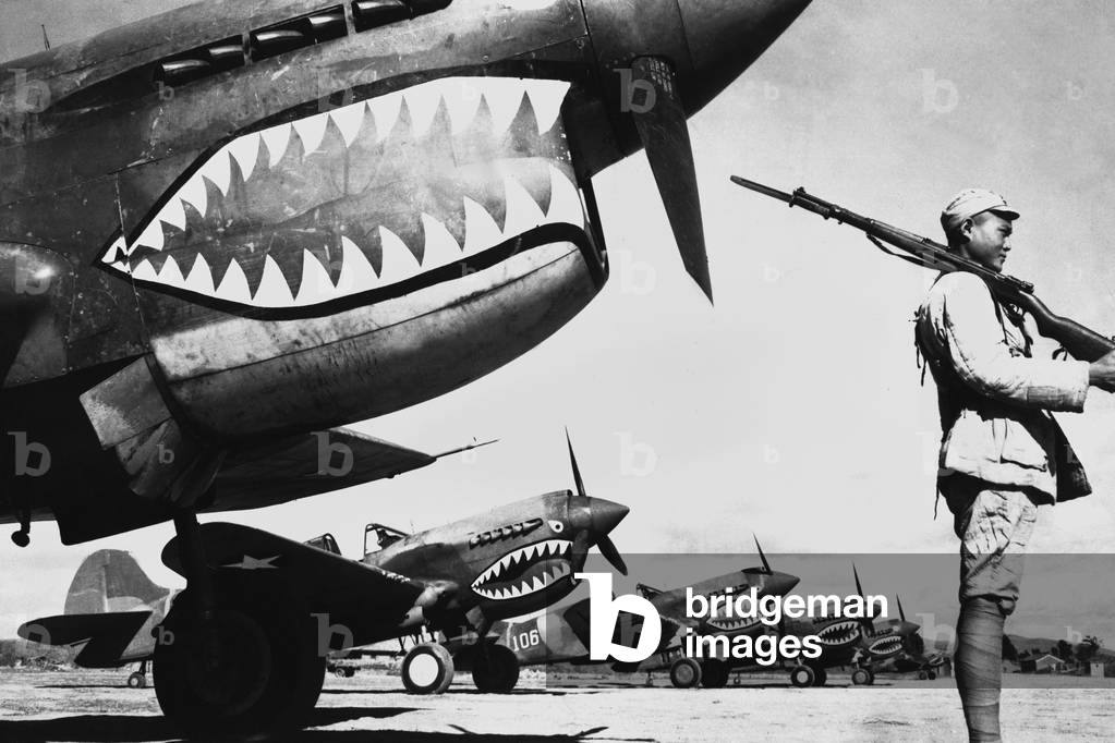 Chinese soldier guards a line of American P-40 fighter planes, c. 1942. The shark-face fighters of the 'Flying Tigers' had a 12-to-1 victory ratio over the Japanese planes during World War 2