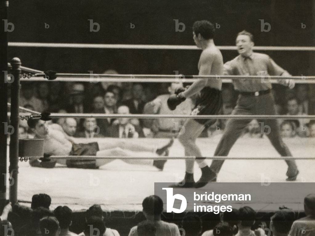 Max Schmeling on the floor for a count of nine in his match with Max Baer. June 8, 1933. Referee Donovan stopped the heavyweight fight after one minute and 51 seconds of the tenth round.