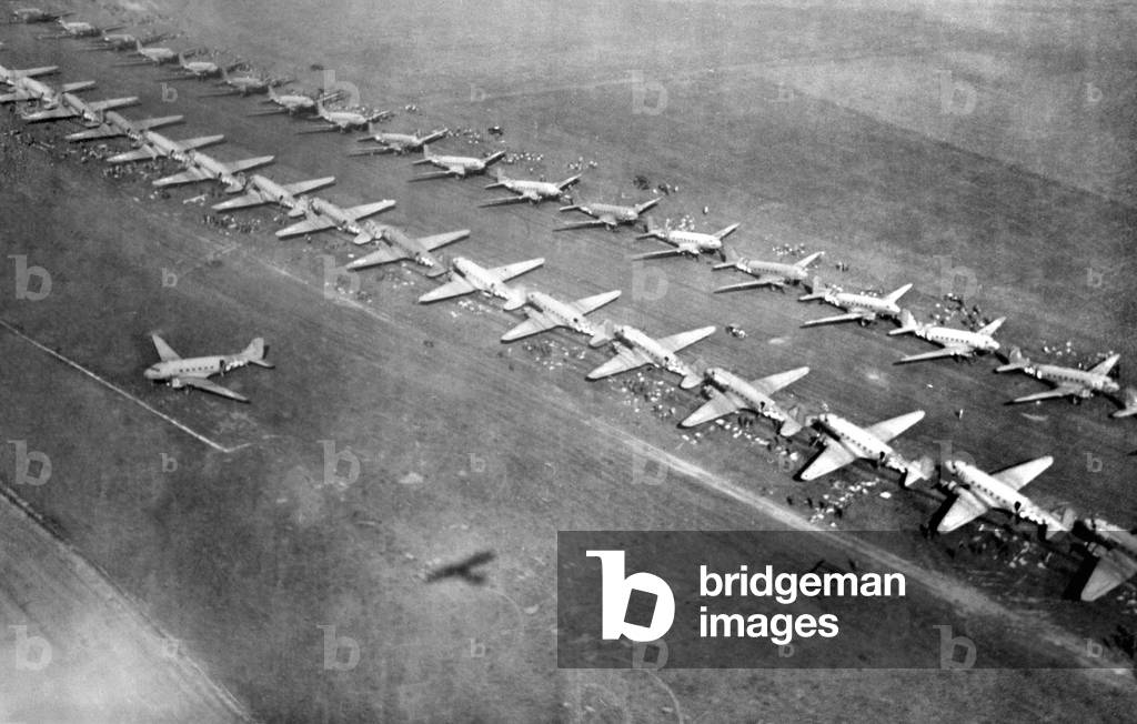 Long lines of C-47 transports loaded with paratroopers at an English airfield, Sept. 17, 1944. Operation Market Garden would drop 34,600 airborne troops near key bridges in the Netherlands. A BRIDGE TO FAR, was a 1977 film based on Cornelius Ryan's 1974 book about the disastrous battle. World War 2