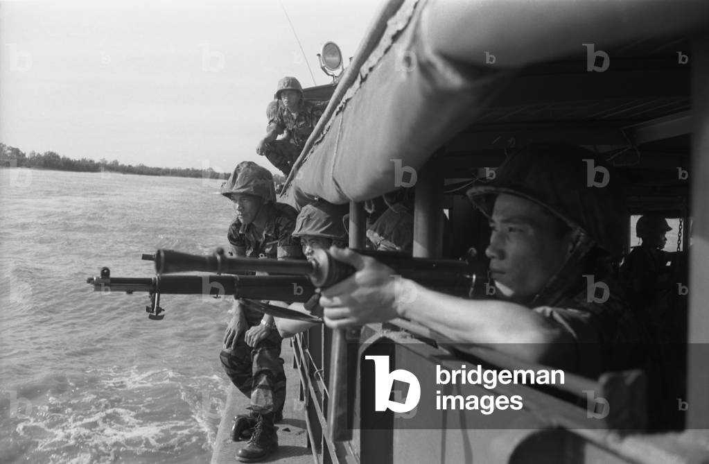 Vietnamese soldiers inspecting the shoreline from inside a boat to prepare for landing. Feb. 15, 1962. Photo by Robert Pepper Martin