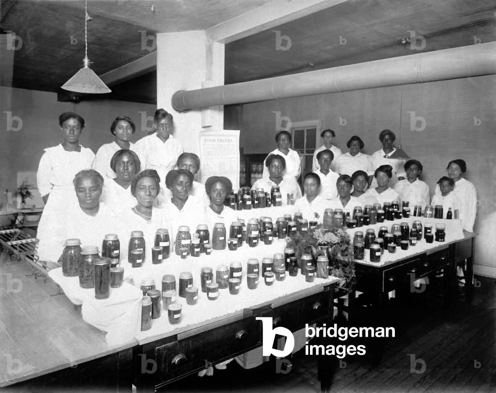 African American high school students pose with food they have preserved. Food production and preservation were encouraged during World War I. School No. 26, Indianapolis, Indiana. c. 1917-18