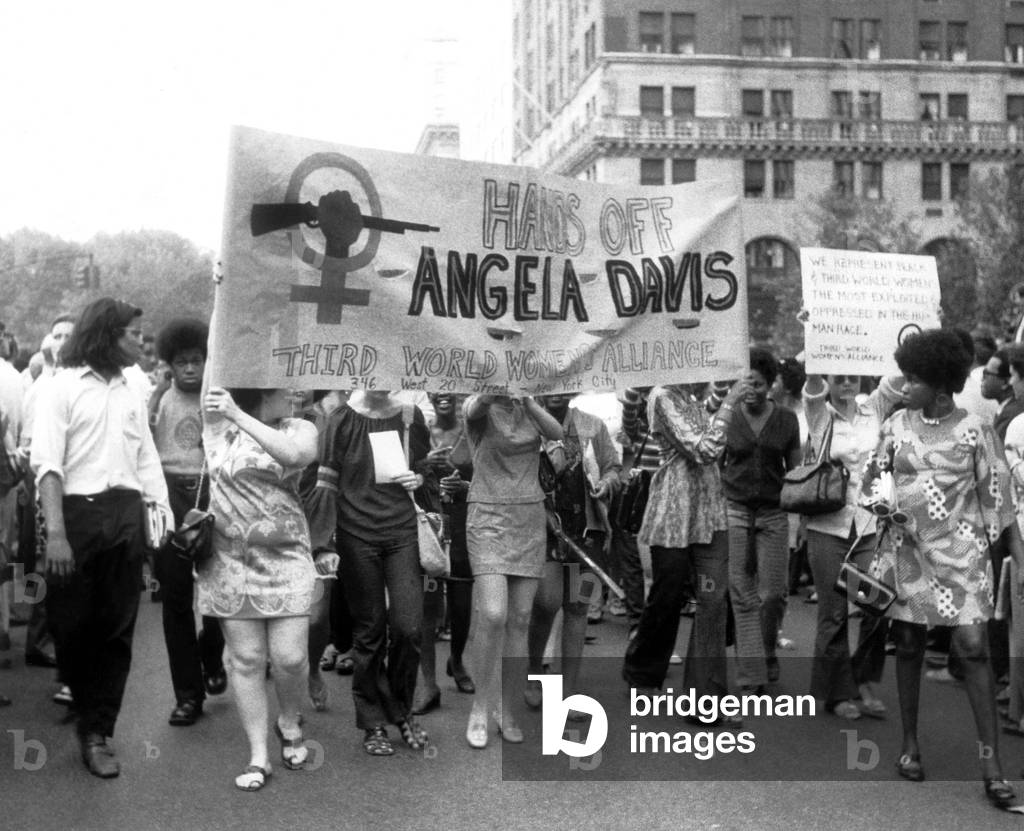 Women's Liberation marchers carrying a banner in support of fugitive black militant Angela Davis, New York City, 08-26-1970