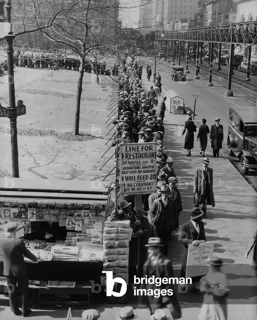 Breadline along Bryant Park in Mid-town Manhattan. A sign advertised meals for 1 cent and requests donations. New York City. 1930s