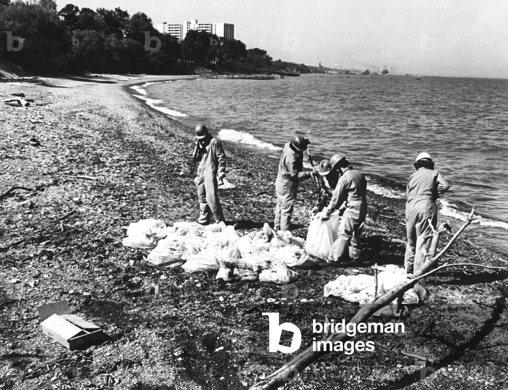 Workers cleaning up oil at the beach of Wildwood/Cleveland Lakefront State Park, c. 1976