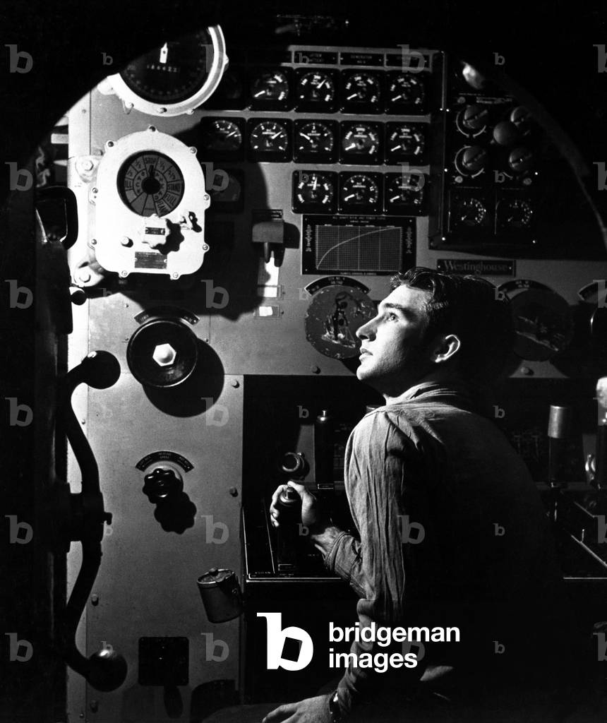 Sailor at work in the electric engine control room of USS BATFISH on submarine war patrol, World War 2, May 1945