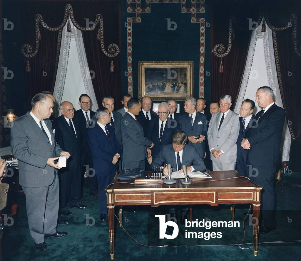 President Kennedy signing the Nuclear Test Ban Treaty which banned nuclear tests in the atmosphere, underwater and in space. First row: Senators Pastore, Fulbright, Aiken, Dirksen, Saltonstall, Kutchel, and VP Johnson. Second Row: Averell Harriman, Sen. Smathers, Sec of State Dean Rusk, Sen. Humphrey, William C. Foster, Sen. Cannon. Oct. 7, 1963