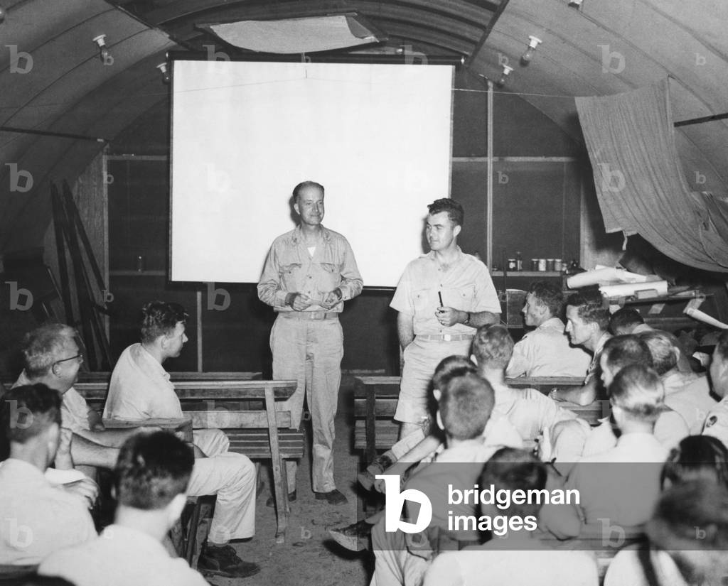 Hiroshima Atomic Bomb Crew at the briefing prior to the flight of the Enola Gay. Capt. William Parsons and Colonel Paul Tibbets go over last-minute data. World War 2. August 6, 1945