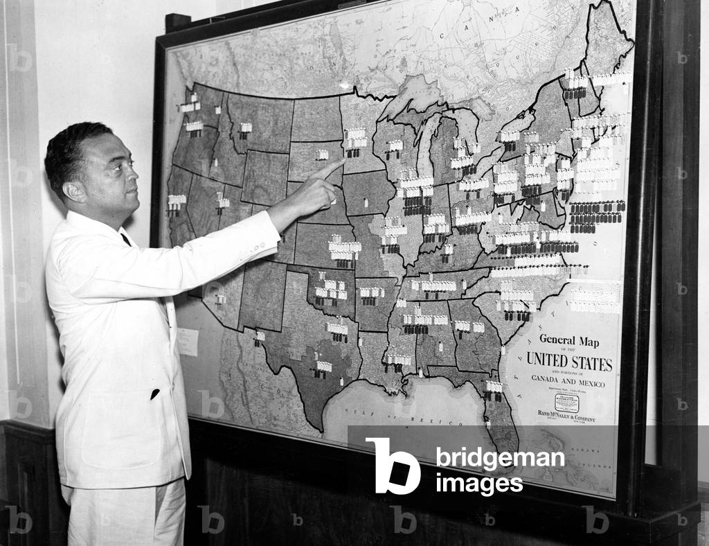 J. EDGAR HOOVER pointing to map showing location of F.B.I. agents throughout the U.S., 07/18/35.