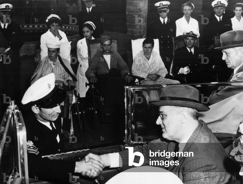 President Franklin D. Roosevelt (right), shakes hands with a chief petty officer at the Naval Hospital at San Diego, Governor Culbert L. Olson stands at roght, California, October, 1942