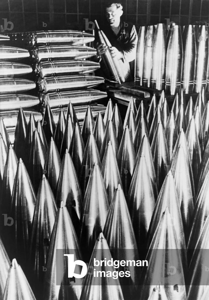 German munitions worker inspecting large shell casings. c. 1939-40. World War 2