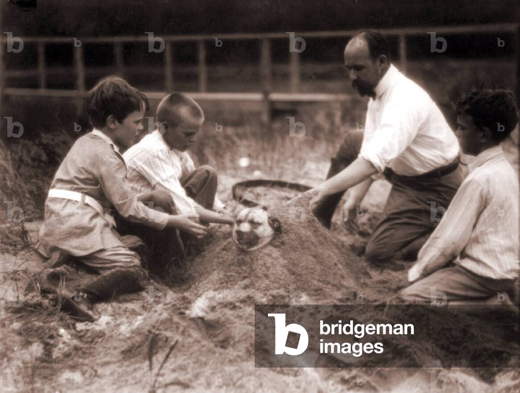 Quentin Roosevelt et Archie Roosevelt: Theodore Roosevelt's sons, Quentin and Archie, are joined by cousin Nicholas Roosevelt and Indian photographer Edward S. Curtis as they bury a very patient dog in sand at Sagamore Hill, Long Island, N.Y. 1904.