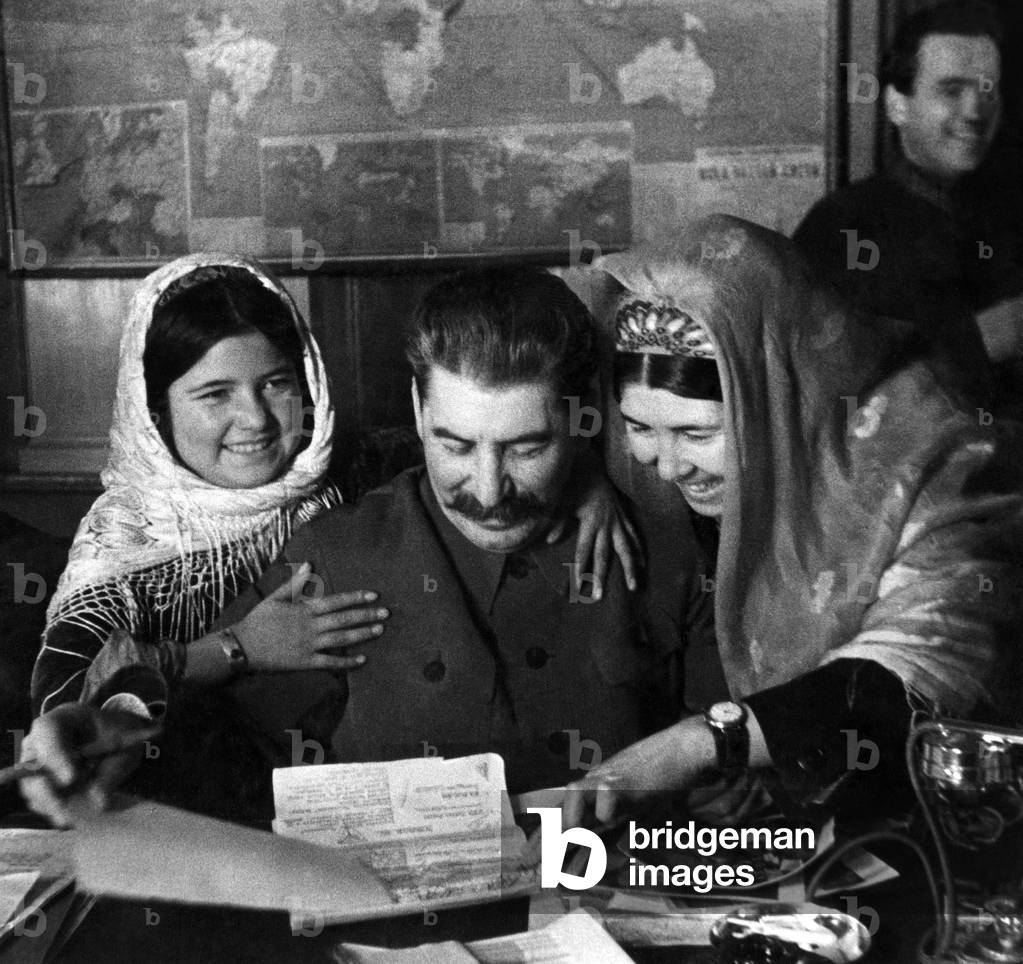 Mamlyakat Nakhangova, Soviet General Secretary Josef Stalin, and Ena Geldieva, at a conference for members of collective farms of the Tadjik Soviet Social Republic and the Turkmen Soviet Socialist Republic, Russia, December 4, 1935