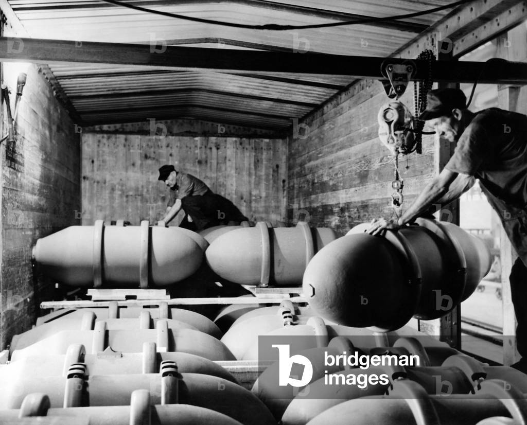 War workers at Blaw-Knox Companys Bomb Finishing Plant load 1,000-pound general purpose bombs into a freight cars. Nov. 27, 1943