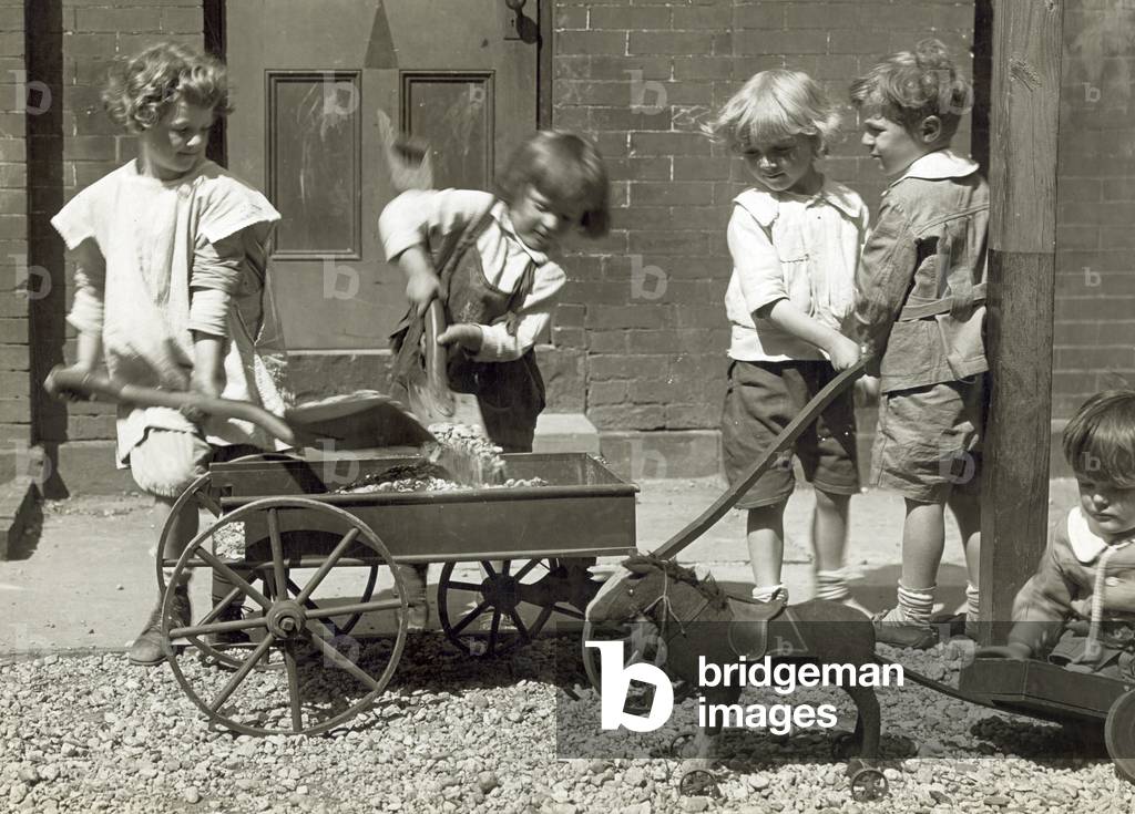 Chrildren playing with rocks, a wagon and a toy pony. Photograph by Jessie Tarbox Beals, 1915