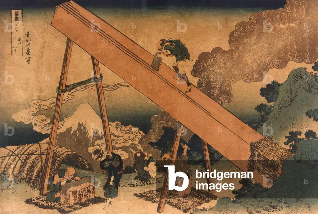 19th century Japanese print shows two men sawing lumber from a large log. Another man is sharpening a saw while a woman with an infant on her back, watches. In the distance is Mount Fuji. Woodcut by Hokusai Katsushika, (1760-1849), c. 1831-32