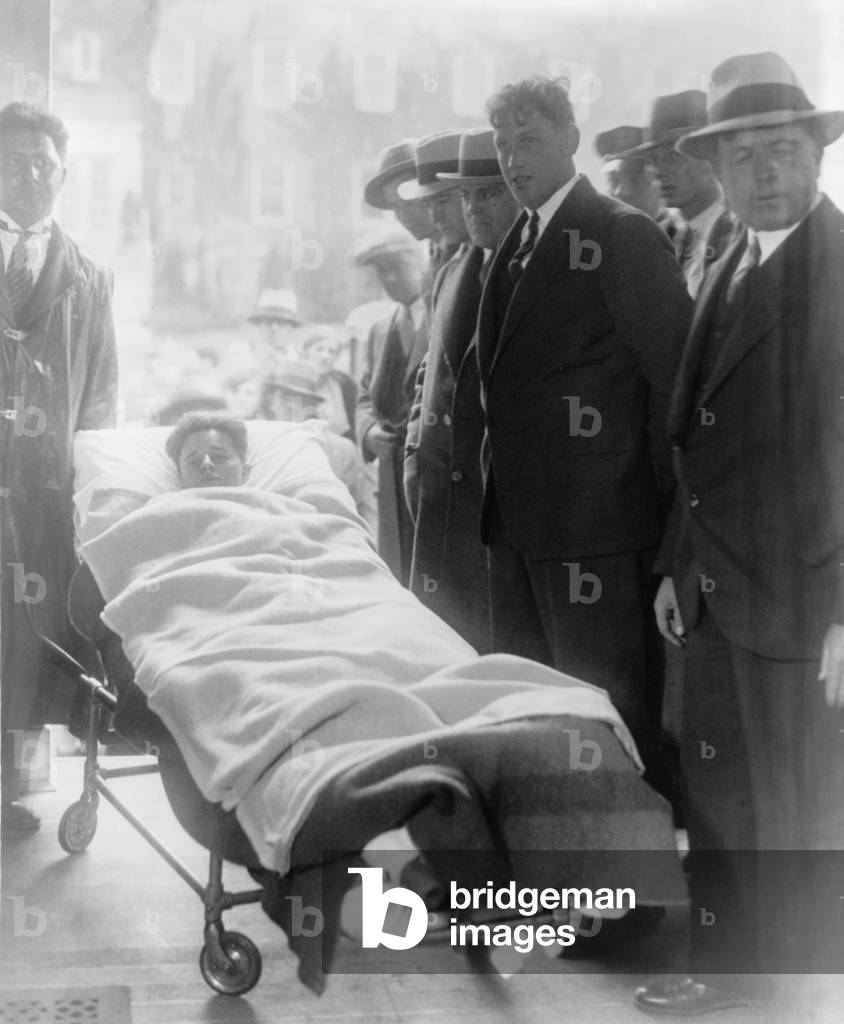 Francis 'Two Gun' Crowley (1911-1932), a robber and cop killer, arrives at his arraignment in a gurney, still recovering from the bullet wounds sustained during his capture by police. May 8, 1931