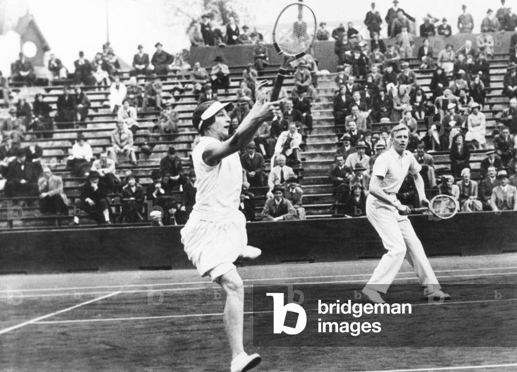 Americans Helen Wills Moody and Sidney Wood, in mixed doubles play in France. May 31, 1932. They placed second, losing the finals to Betty Nuthall and Fred Perry of Britain at the Roland Garros Stadium, Auteuil, France