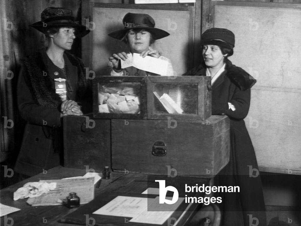 Three women's suffragists casting votes in New York City, c. 1917
