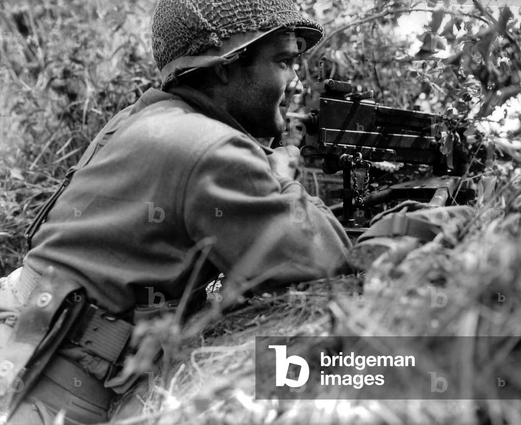 Soldier positioned in a ditch with gun Browning machine gun in Normandy, France. He is part of Operation Cobra, code name for First U.S. Army's offensive to breakout of Normandy. July 27, 1944. France, World War 2
