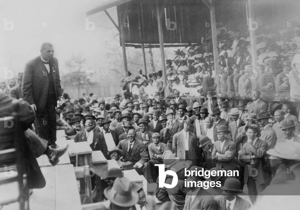 Booker T. Washington addressing a laughing crowd of African American men in Lakeland, Tennessee, during his campaign promoting African American education. c. 1900