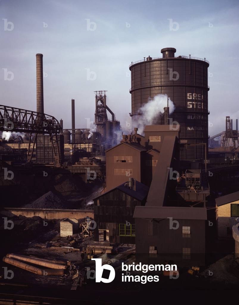 Hanna furnaces of the Great Lakes Steel Corporation, Detroit, Michigan. The tank stores gas from the coke oven. Square building and extension in middle ground is where coal is fed to the coke oven