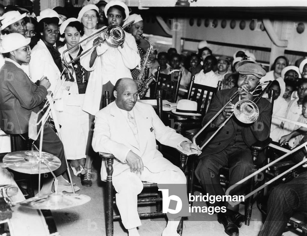 Father Divine is serenaded by followers on the steamer, Aug. 8, 1937. He is bound for his cult's 'Promised Land Olympic Games,' in Kingston, N.Y. Of the claimed expectation of 100,000 attendance, only 2000 showed up. -