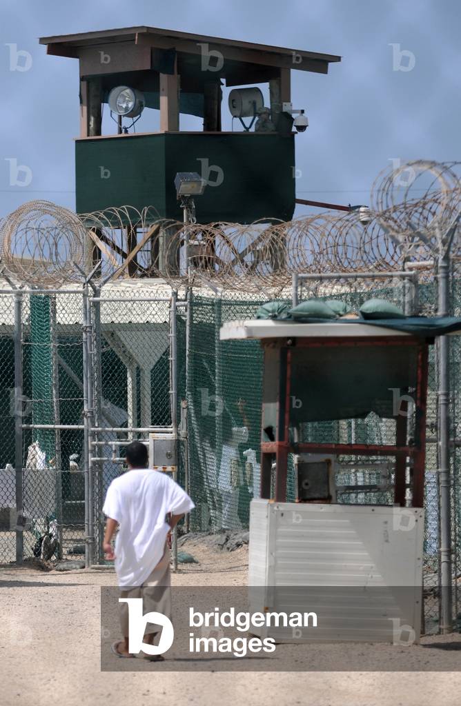 Under the guard tower a detainee walks in the recreation yard at Camp Delta the military prison for suspected Taliban and Al-Qaeda combatants at Guantanamo Bay Naval Base Cuba. June 8 2010., Photo by:Everett Collection
