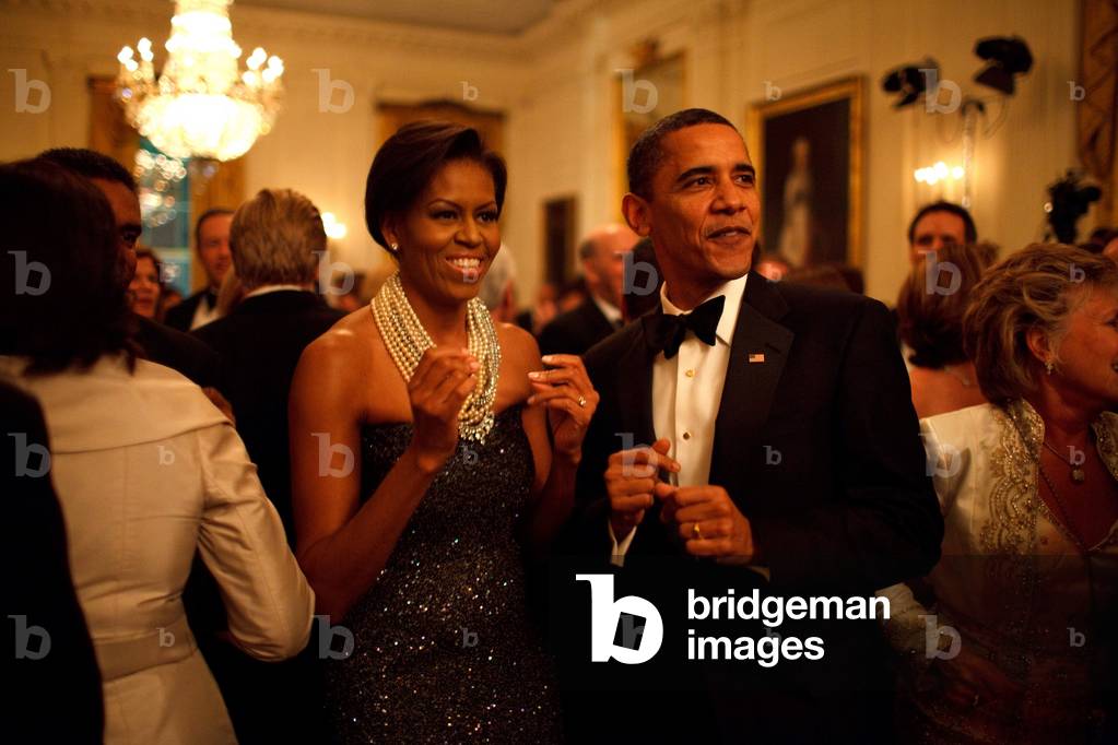 President and Michelle Obama applaud the band 'Earth Wind and Fire' at the Governors Ball at the White House. Michelle wears a deep purple sequined strapless gown by Peter Soronen with a multi-stranded necklace of pearls and crystals by Tom Binns. Feb. 22 2009.,