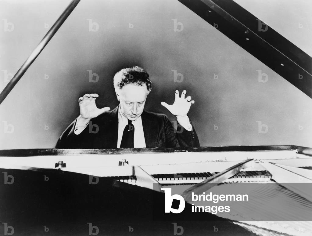 Artur Rubinstein (1887-1982), a grand piano, with his hands raised in 1961. The Polish born pianist became an American citizen in 1946