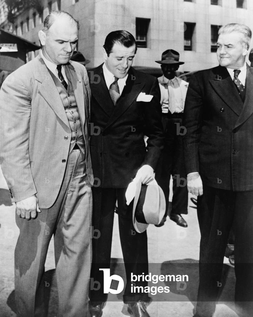 Benny 'Bugsy' Siegel (1906-1947), under arrest and in the custody of U.S. Marshals in Los Angeles. 1941. Warren Beatty played Seigel in the 1991 film BUGSY