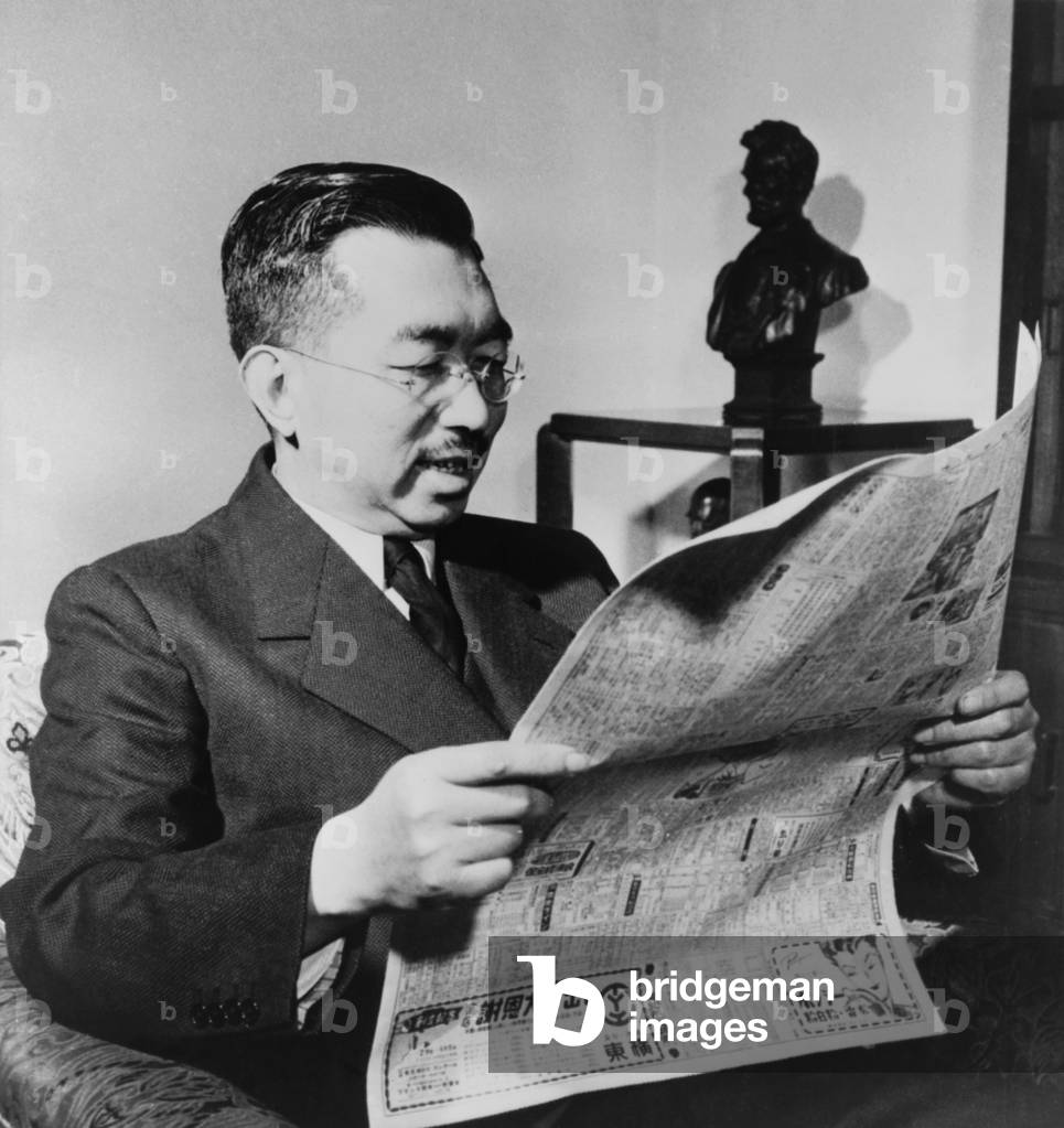 Emperor Hirohito happily reads about the signing of a peace treaty between the U.S. and Japan. The Treaty marked the end of U.S. Occupation of Japan. In the background is a statue of American President, Abraham Lincoln. 1952.