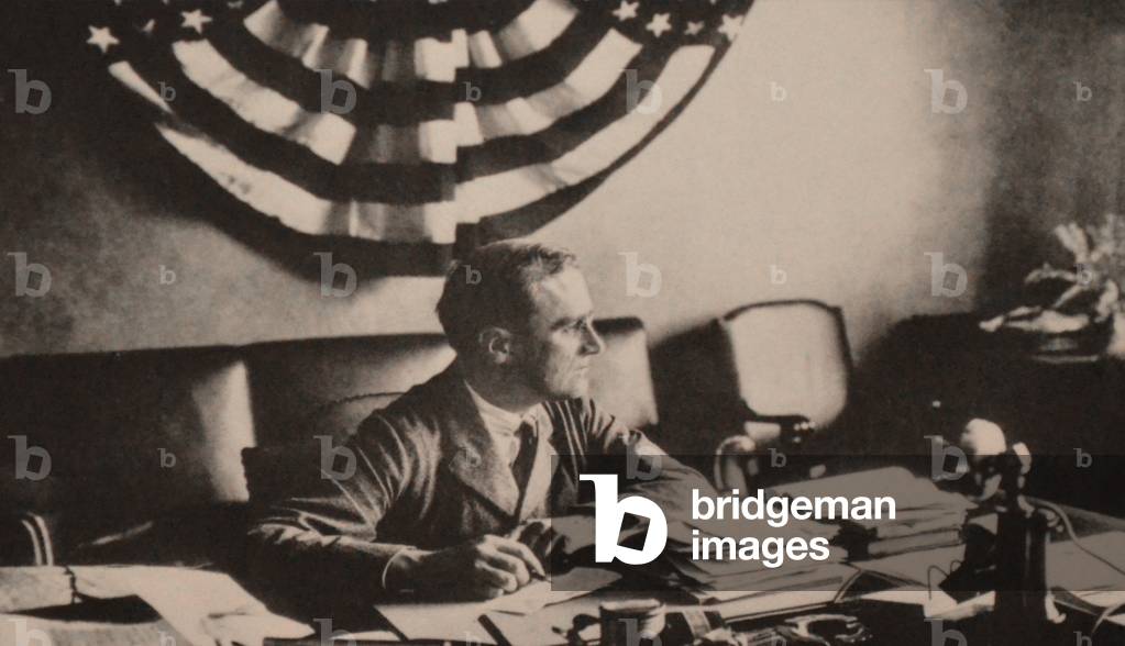 Franklin Roosevelt in his Hyde Park study in 1923. The striped bunting, correspondence, and telephone indicate FDR is back at work