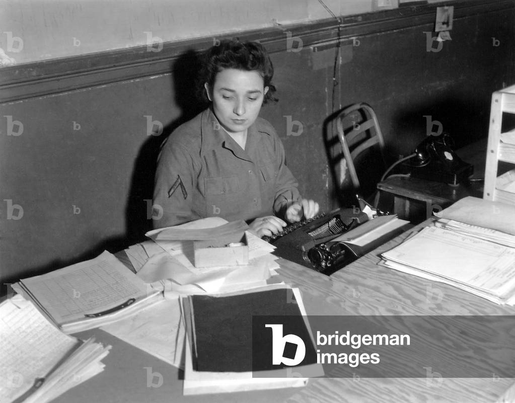 U.S. WAC Private First Class typing at a rough plywood desk in Normandy, France in 1944. World War 2