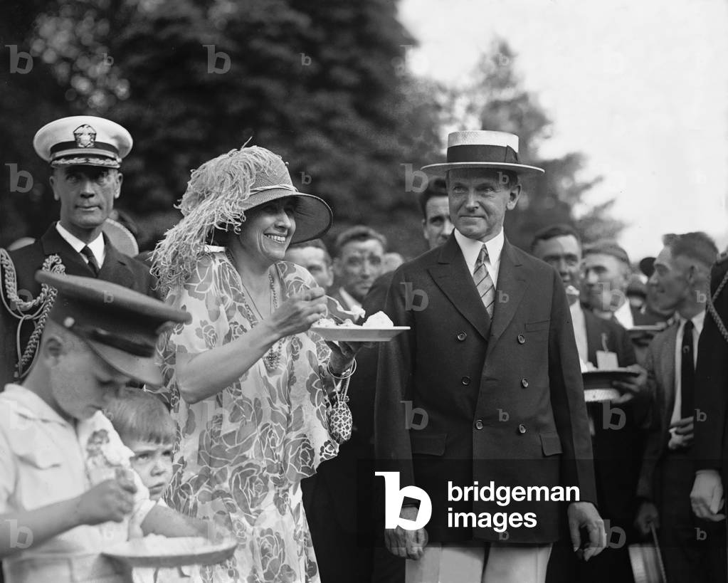 President Calvin Coolidge (1872-33) smiles along with his wife at a White House garden party in June 1926