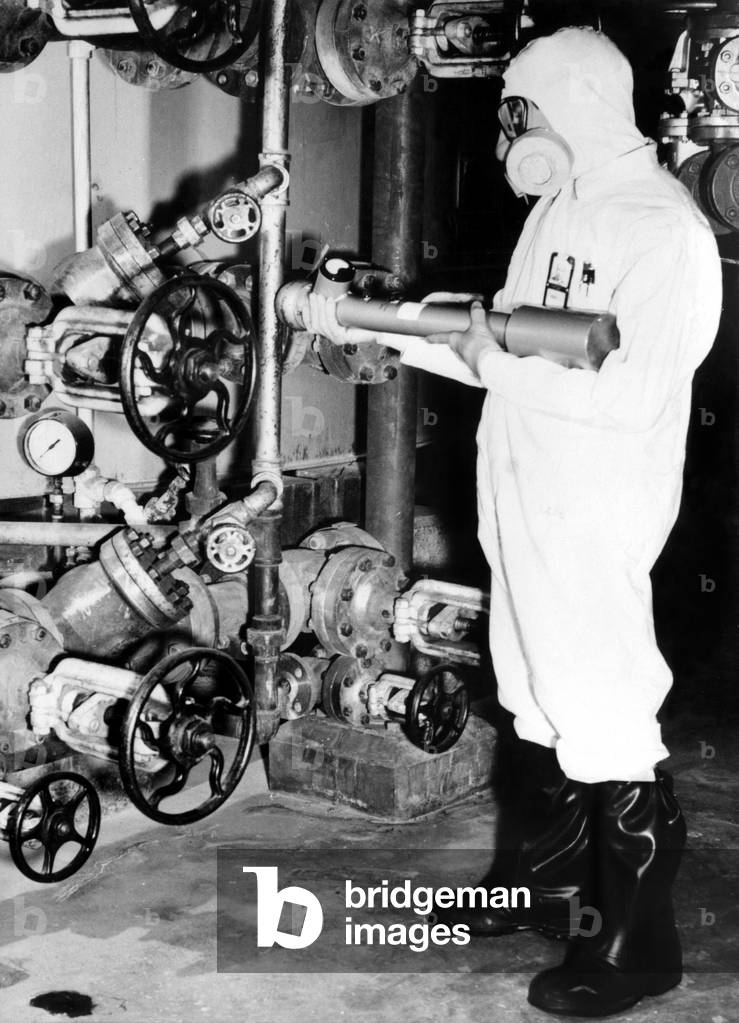 General Electric worker with a portable radiation detector checking for probable 'hot zones' at the Hanford Atomic Products Operation, Richland, WA, 1955
