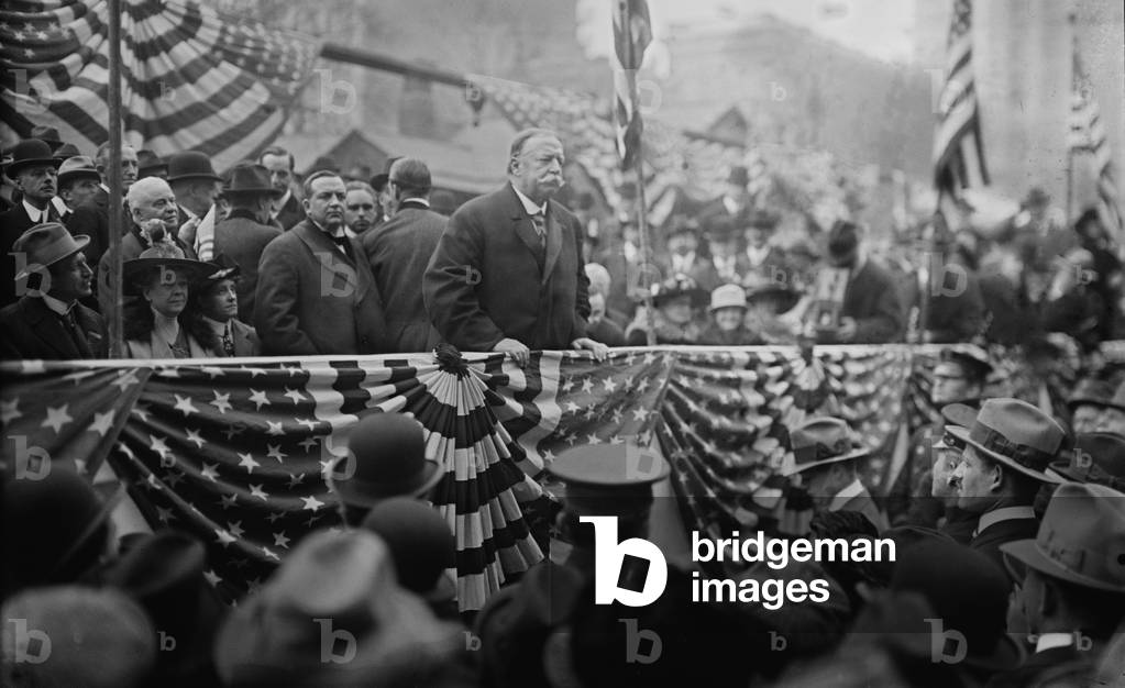 President William Taft (1857-1930) speaking on a flag draped podium in 1909