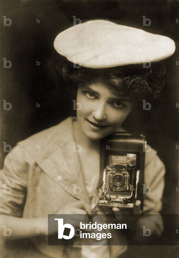 THE KODAK GIRL, a pretty girl posed with camera in a 1909 Kodak advertisement