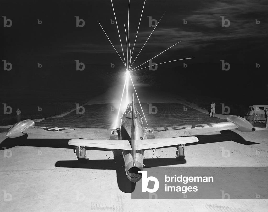 F-84 Thunderjet firing .50 caliber tracer bullets as maintenance men test the wing guns. The jet will be on a bombing and strafing mission the following day during the Korean War, 1950-53