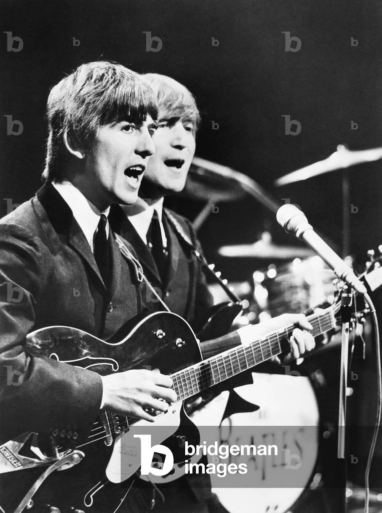 George Harrison (left) and John Lennon of the Beatles. c. 1964