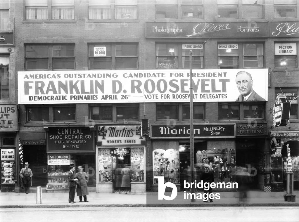 Banner for Franklin Roosevelt in Worcester, Massachusetts. April 1932. The large sign spans across two buildings, urging people to vote for FDR in the Democratic primary