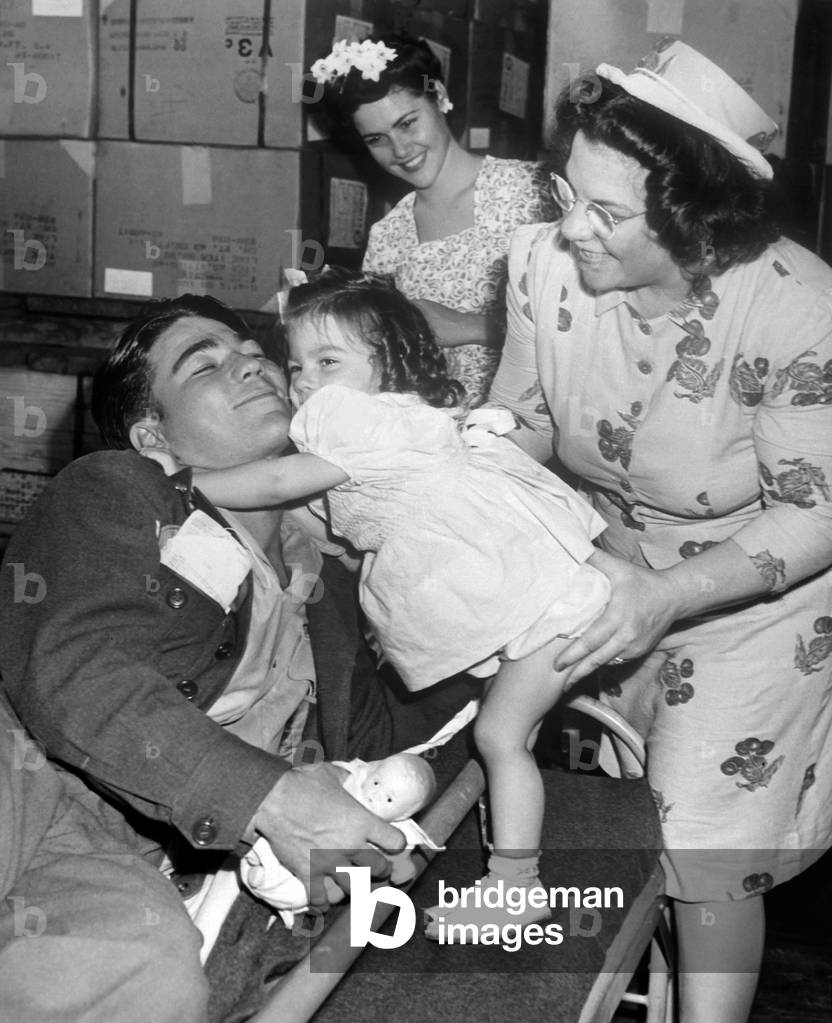 Wounded U.S. soldier's homecoming in New York City at the end of World War 2. He was wounded in Normandy and greeted by his baby sister, mother and wife. Aug. 1, 1945
