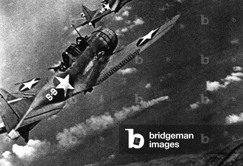 Battle of Midway, June 4-6, 1942. U.S. Douglas SBD-3 Dauntless dive bomber from the USS Hornet continues the attack on the burning Japanese cruiser Mikuma, June 6, 1942. The World War 2 battle stopped the Japanese Pacific expansion and sank four Japanese aircraft carriers