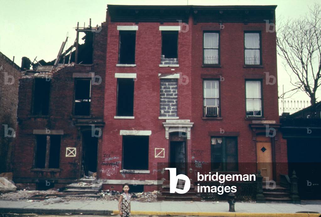 Substandard housing in Brooklyn New York City. People are still living in the building next to burnt ruins. June 1974