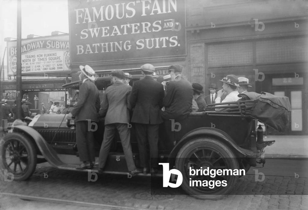 Men ride on the running boards of a improvised mass transit vehicle during a strike in Brooklyn, c. 1915