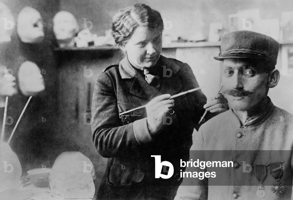 Disfigured WW1 Veteran's mask gets finishing touches by sculptor Anna Ladd. 1918. The French soldier's mask of sculpted and painted copper was made by American artist in July 1918