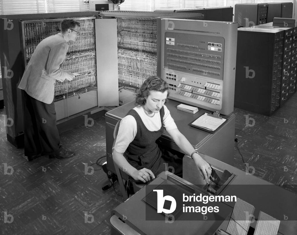 Technicians working with room size IBM type 704 computer making calculations for aeronautical research. NASA Langley Research Center, March 21, 1957